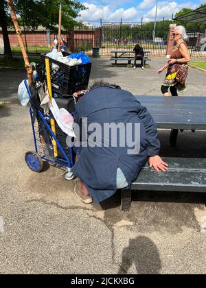 Une personne apparemment sans abri dort à une table de pique-nique au parc Parade près de Prospect Park à Brooklyn, New York. Banque D'Images