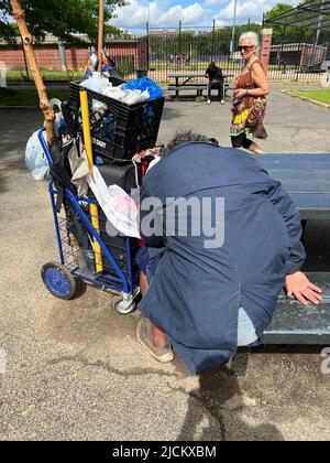 Une personne apparemment sans abri dort à une table de pique-nique au parc Parade près de Prospect Park à Brooklyn, New York. Banque D'Images