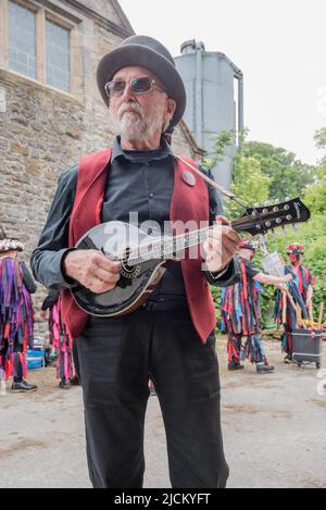 Le musicien de Flagcrackers soutient le côté de Craven Border Morris dans des vestes de chiffon colorées qui exécutent des danses au Cappelside Open Farm Day à Rathmell . Banque D'Images