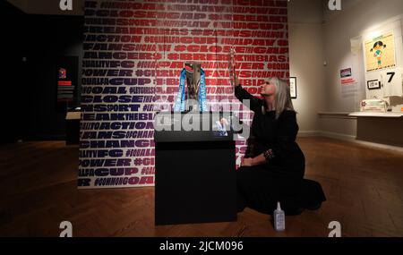 Brighton, Royaume-Uni. 14th juin 2022. Helen Grundy, responsable des expositions, polit le cabinet contenant le Barclays FA Women's Super League Trophée qui fait partie de l'exposition de football des femmes Goal Power au musée et galerie d'art de Brighton. Credit: James Boardman / Alamy Live News Banque D'Images