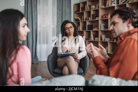 Problèmes dans la famille et consultation avec le psychologue. Triste couple millénaire européen en conversation avec un professionnel Banque D'Images