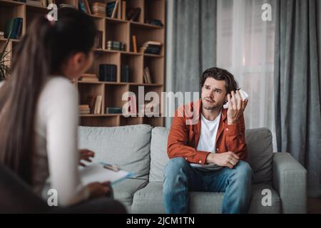 Stress, douleur et pression. Un jeune médecin caucasien consulte un client mâle criant avec une serviette en clinique Banque D'Images