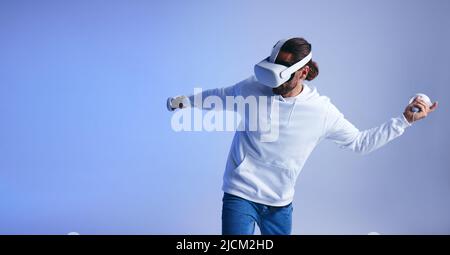 faire la fête dans la métaverse. Heureux jeune homme dansant et s'amusant tout en portant un casque de réalité virtuelle. Jeune homme jouissant d'une simulation 3D dans un stu Banque D'Images