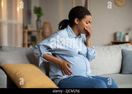 Femme noire enceinte souffrant de nausées ayant la maladie du matin à l'intérieur Banque D'Images