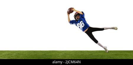 Petit garçon sportif en uniforme sportif et équipement jouant au football américain isolé sur fond blanc avec sol en herbe verte. Concept de sport Banque D'Images