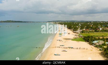 Sri Lanka - 25 août 2021: Vue aérienne d'un groupe de pêcheurs tirant des filets de la mer. Trincomalee. Banque D'Images