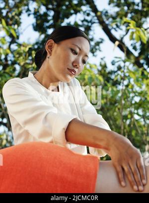 Femme recevant un massage tibétain au coucher du soleil, Ananda Spa, Ananda dans l'Himalaya, le Palace Estate, Narendra Nagar, Tehri Garhwal, Uttarakhand, Inde. Banque D'Images