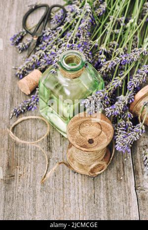 Fleurs de lavande et bouteille d'huile à base de plantes sur fond de bois rustique vintage Banque D'Images