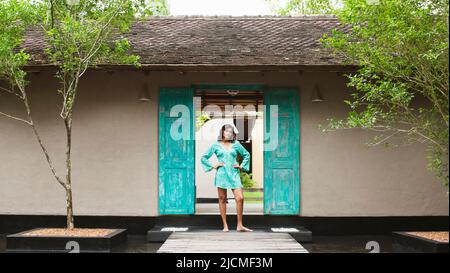 Une jeune femme se tient à l'entrée d'un spa. Aturuwella, Bentota, Sri Lanka. Banque D'Images