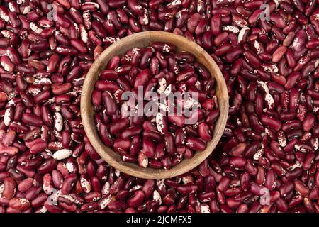 arrière-plan de nombreux grains de haricots secs vue de dessus, haricots rouges dans un bol en bois, fond de nourriture gros plan Banque D'Images