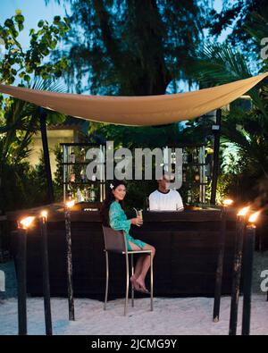 Femme prenant un verre au bar de la plage. Phuket, Thaïlande. Nai Yang Beach au crépuscule. Phuket, Thaïlande. Banque D'Images