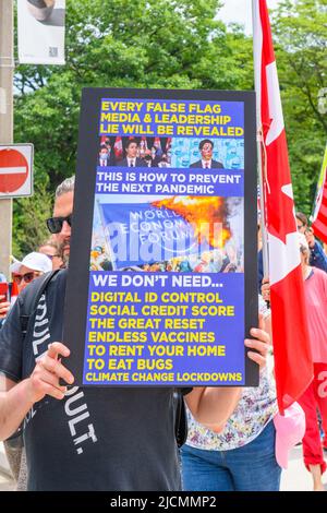 Un homme tient un panneau lors d'une manifestation qui a pris le mot sur le Festival de rue dans le Queen's Park Circle. Banque D'Images