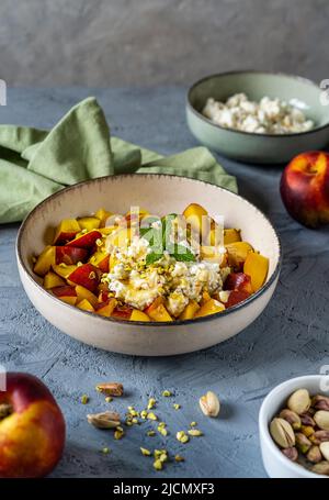 Salade de fruits saine à la nectarine, crème à la ricotta aux pistaches et au miel Banque D'Images