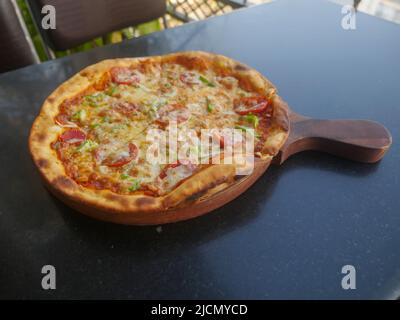 Pizza au fromage végétarien indien, nappée de tomates, de poivrons et d'oignons. Pizza aux légumes en inde Banque D'Images