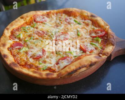 Pizza au fromage végétarien indien, nappée de tomates, de poivrons et d'oignons. Pizza aux légumes en inde Banque D'Images