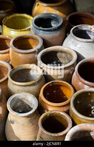 Beaucoup de cruches et vases en argile uniques et colorés faits à la main de formes diverses sur l'étagère dans le marché local Banque D'Images