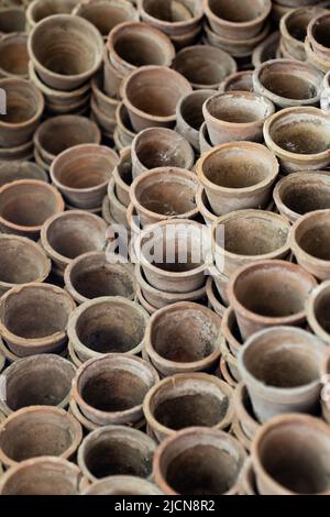 Gros plan des piles de pots de fleurs de terre cuite anciens et altérés dans le hangar de jardinage Banque D'Images