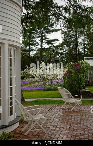 Deux chaises longues sur un patio en briques sous la pluie à l'extérieur de la maison et du jardin Stevens-Coolidge. North Andover, Massachusetts, États-Unis. Banque D'Images