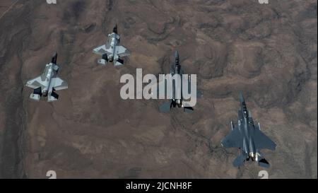 Deux pygargues F-35A Lightning IIS et deux pygargues F-15E Strike volent dans une formation après une mission d'entraînement au combat dans l'espace aérien du champ d'essai et d'entraînement du Nevada pour signifier l'histoire de l'escadron 65th de l'agresseur et sa réactivation à la base aérienne de Nellis, Nevada, 9 juin 2022. L'AGRS 65 était auparavant actif à Nellis de 2005 à 2014. Pendant ce temps, l'unité a répliqué des tactiques et des techniques d'adversaires potentiels avec une flotte de F-15 Eagles. (É.-U. Photo de la force aérienne par Tech. Sgt. Alexandre Montes) Banque D'Images