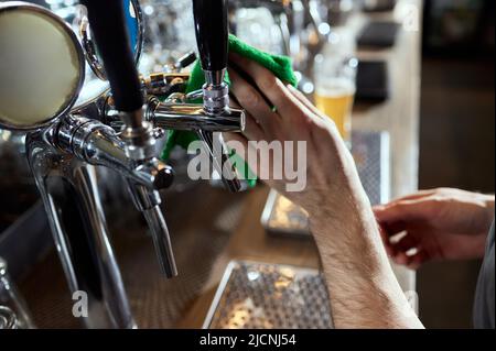 Gros plan des robinets à bière de la rangée. Équipement métallique pour barres et mini-brasseurs. Concept d'équipement moderne. Chiffon de nettoyage Banque D'Images