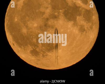 Sheerness, Kent, Royaume-Uni. 14th juin 2022. Météo au Royaume-Uni : un jet de haute altitude est vu pour laisser un sentier de vapeur en passant devant la Super Strawbery Moon au-dessus de Sheerness, Kent ce soir. Crédit : James Bell/Alay Live News Banque D'Images