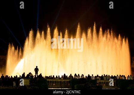 Barcelone, Espagne - 5 octobre 2018 : des gens silhouetés devant le spectacle de nuit de la fontaine magique colorée entourée par le public bondé. Banque D'Images