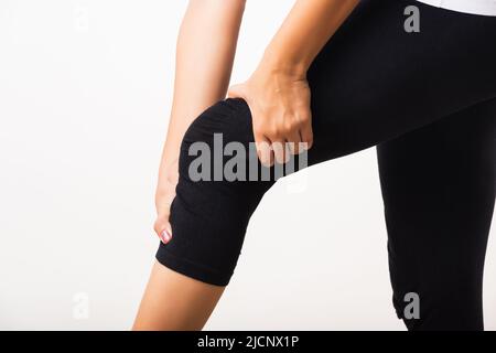 Gros plan de la jeune femme douleurs à souffrir de la douleur genou et elle utilise main joint tenir genou agonie, studio shot isolé sur fond blanc rhumatism santé Banque D'Images