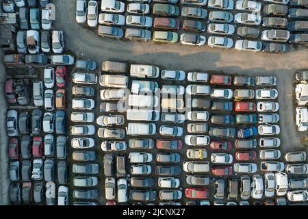 Vue aérienne du grand parking de junkyard avec des rangées de voitures brisées jetées. Recyclage des vieux véhicules Banque D'Images