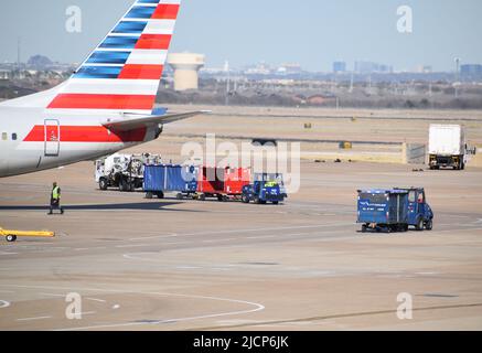 Un avion d'American Airlines desservi par des agents de service de rampe à l'extérieur d'un terminal à l'aéroport DFW (aéroport de Dallas-fort Worth) Banque D'Images