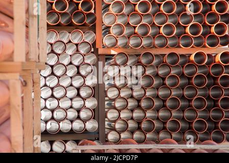 Arrière-plan des tuyaux d'égout en plastique orange utilisés sur le chantier. Texture et motif du tuyau d'évacuation en plastique. Lumière dans les tubes. Banque D'Images