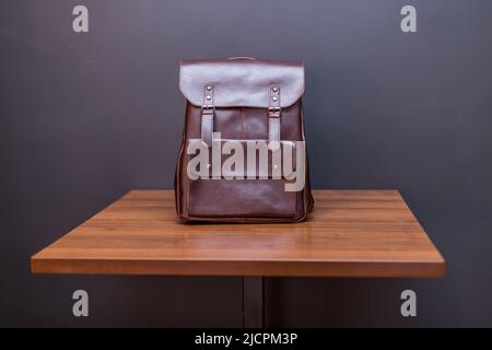 Sacs à dos en cuir marron sur une table en bois. Sac unisexe Banque D'Images