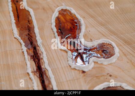 Gros plan de la résine époxy séchée dans la table en bois. Procédé de fabrication d'une table de résine et de bois d'artisanat Banque D'Images