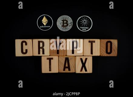 Bichkek, Kirghizistan - 25 mars 2022: Crypto des mots de taxe sur des cubes de bois avec des pièces de Bitcoin, Ethereum, Cardano Banque D'Images