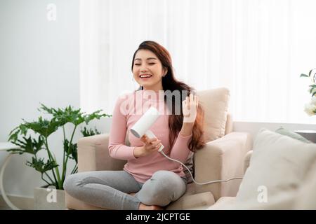 Soins capillaires.Belle femme aux cheveux longs séchant les cheveux Banque D'Images