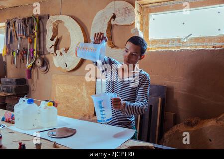 Menuisier préparant de la résine époxy pour le travail du bois et la menuiserie Banque D'Images