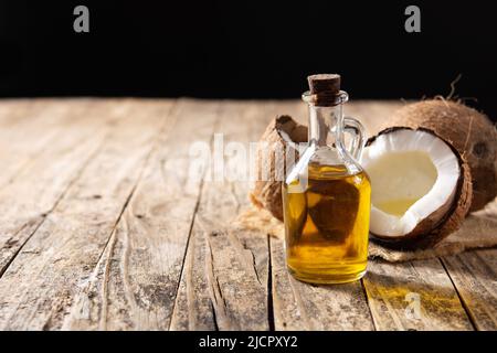 Coconut oil and oil bottle on wooden table Banque D'Images