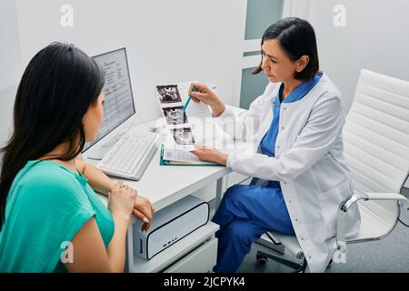 médecin et femme patient parle dans le bureau gynécologique lors de la visite au bureau gynécologique. Consultation de gynécologue Banque D'Images