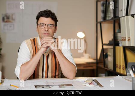 Portrait de l'architecte travaillant à sa table avec des plans et des palettes de couleurs Banque D'Images