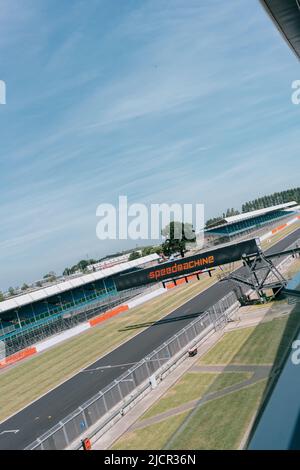 Vue VIP depuis le balcon de l'aile Silverstone : Hamilton Straight, grille de départ, portique de feux et stands de spectateurs vides. Circuit Silverstone, Speedmachine Banque D'Images