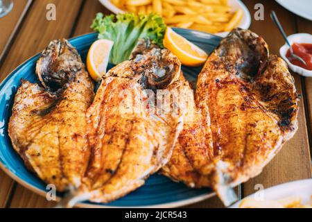 Plat à la bream à tête dorée poisson aux frites et à l'orange. Dorada, Dorade, dorado, Dourada Fish and chips Banque D'Images