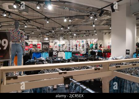 Batumi, Géorgie - 31 mai 2022 : à l'intérieur de la boutique de vêtements New-yorkais. Le magasin de mode est situé dans le centre commercial. Vêtements sur cintres ou étagères. Banque D'Images