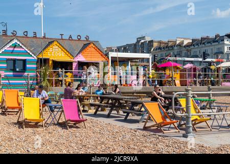 Hastings, East Sussex, Royaume-Uni. 15 juin 2022. UK Météo: Chaud et ensoleillé à la station balnéaire de Hastings dans East Sussex comme Brits Profitez du temps chaud aujourd'hui le long de la promenade du front de mer. Transats colorés sur la plage dans ce café. Crédit photo : Paul Lawrenson /Alay Live News Banque D'Images