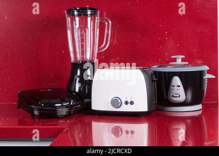 Appareils électroménagers dans une cuisine moderne de fond rouge. Banque D'Images