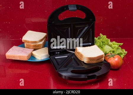 Appareil à croque-monsieur; photo avec les ingrédients pour faire des sandwichs. Banque D'Images