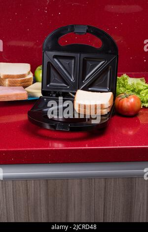 Appareil à croque-monsieur; photo avec les ingrédients pour faire des sandwichs. Banque D'Images