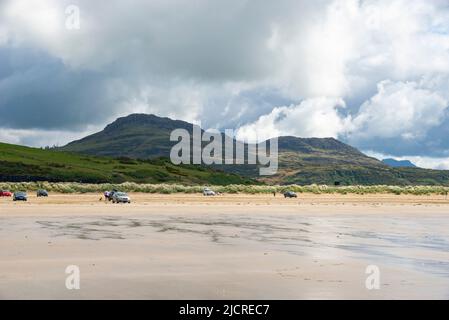 Touristes garés sur Black Rock Sands près de Porthmadog sur la côte du nord du pays de Galles. Moel y Gest en arrière-plan. Banque D'Images