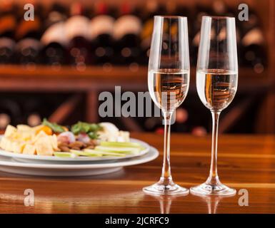 Deux verres de champagne avec plateau de fromage. Banque D'Images