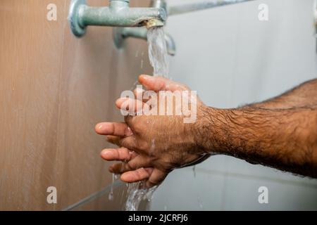 Gros plan du chirurgien se laver les mains après l'opération en retirant des gants - concept d'hygiène, mesures de sécurité et traitement de santé. Banque D'Images