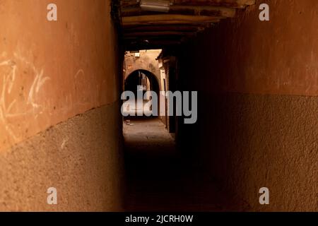 Ombres dans un ancien passage souterrain sur une rue vide de la ville historique fortifiée de la Médina de Marrakech, Maroc. Banque D'Images