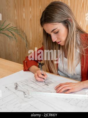 Vue de face portrait d'une femme architecte dessinant des croquis en studio Banque D'Images